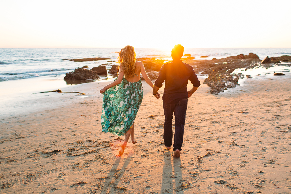 Romantic Couple running on the beach in Laguna Beach for Engagement Photos