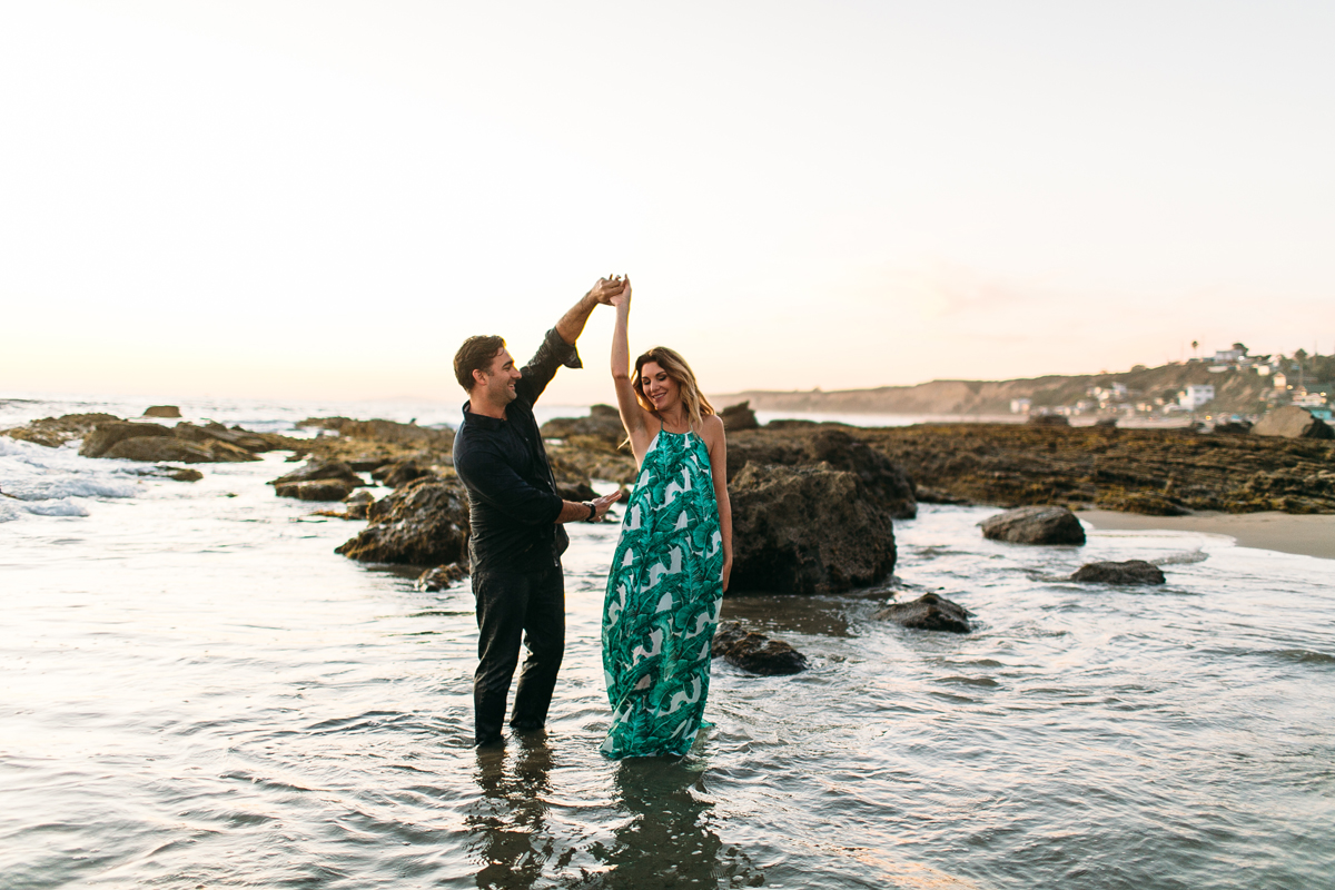 Romantic Couple playing in the ocean in Laguna Beach for Engagement Photos